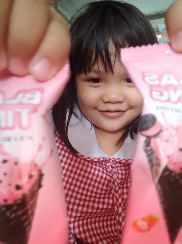 Little girl laughing surrounded by colorful balloons